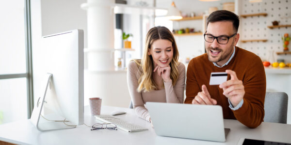 Portrait of a cheerful couple in love shopping online. Technology, e-commerce, banking concept